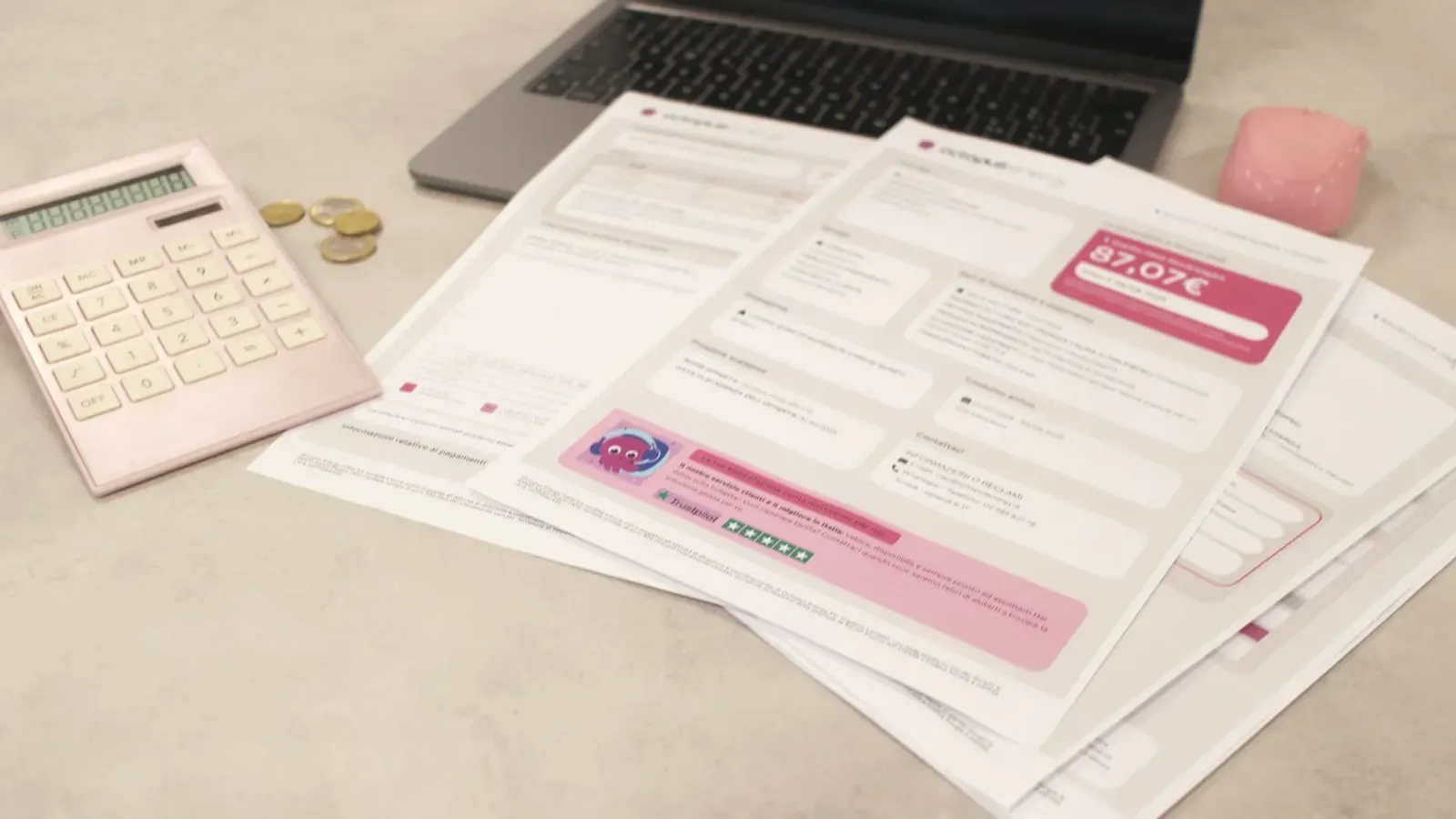 Calculadora, moedas e contas espalhadas sobre uma mesa