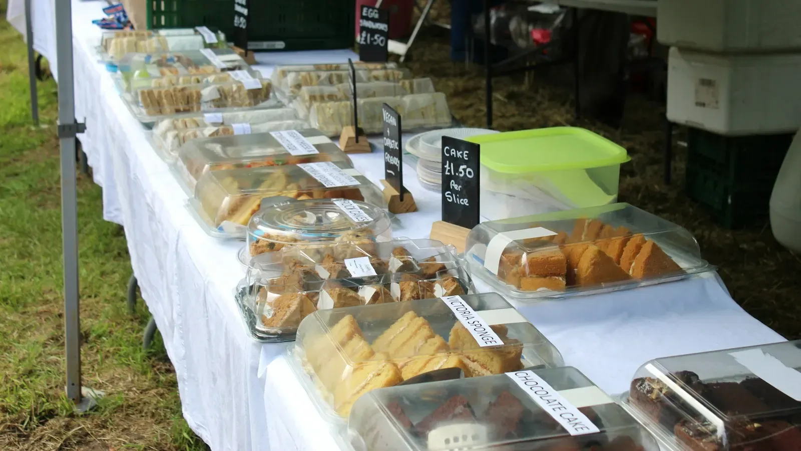 A market stall of home-baked cakes and slices, with small handwritten price signs