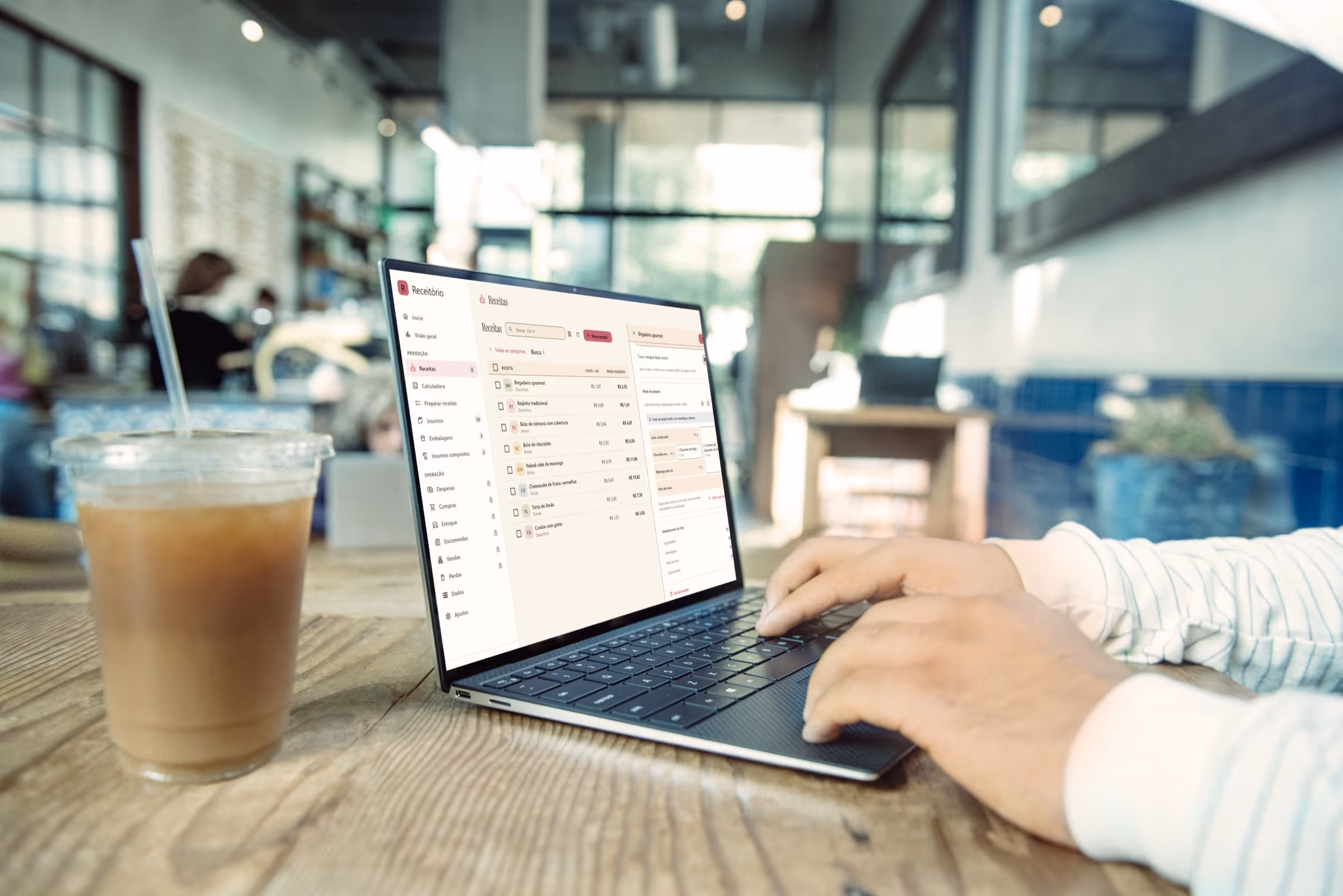 Een laptop met Receitório voor Windows open op het receptenscherm, op een aanrecht naast een kop koffie